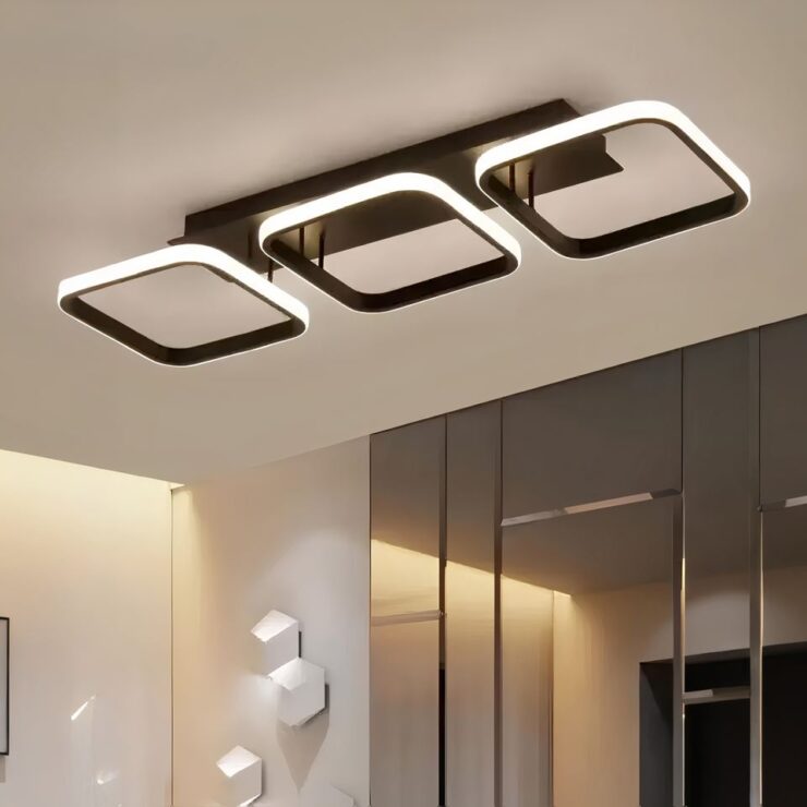 Lustre sans fil avec formes géométriques lumineuses. Le socle rectangulaire est noir. 3 carrés noirs alignés avec l'extérieur lumineux sont tenus par des tiges noires.