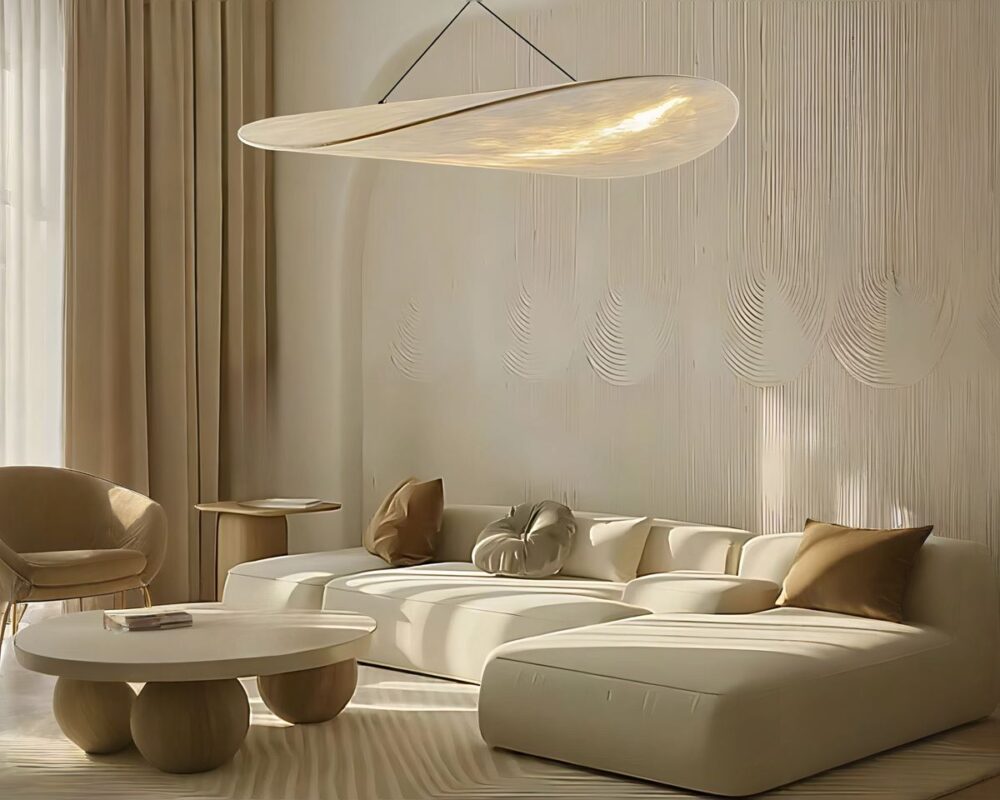 Lustre de salon en forme de nuage, allumé et suspendu au-dessus d'un canapé blanc dans un salon.