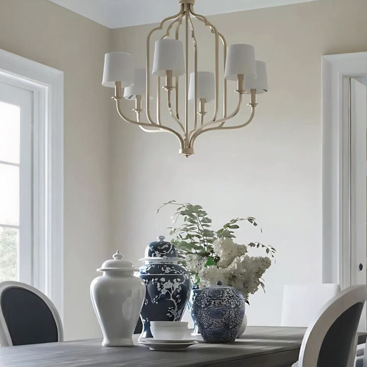 Lustre à abat-jour de style américain en métal suspendu au-dessus d'une table de salla à manger sur laquelle sont posés de beaux pots traditionnels asiatiques ainsi que des fleurs dans un vase.