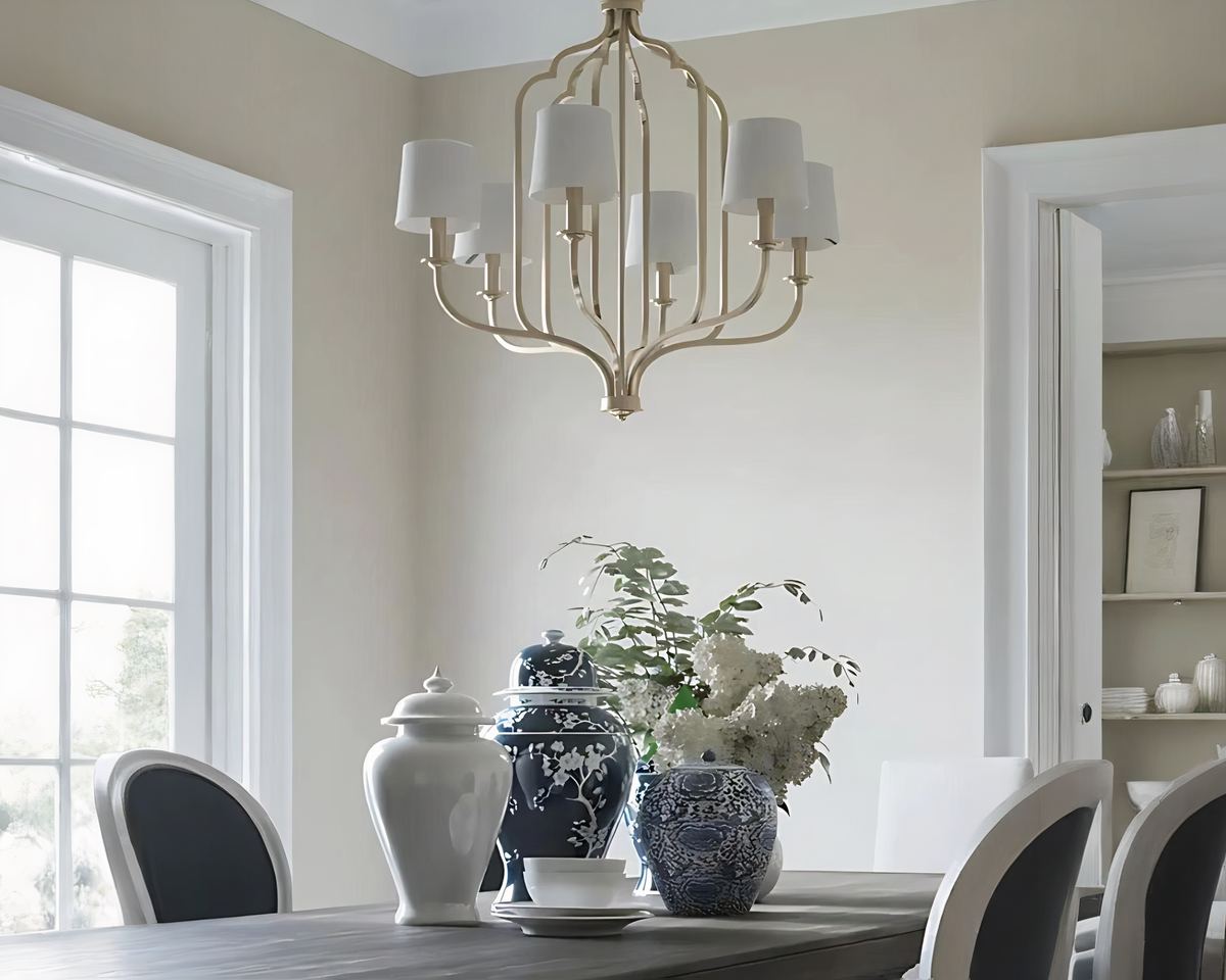 Lustre à abat-jour de style américain en métal suspendu au-dessus d'une table de salla à manger sur laquelle sont posés de beaux pots traditionnels asiatiques ainsi que des fleurs dans un vase.