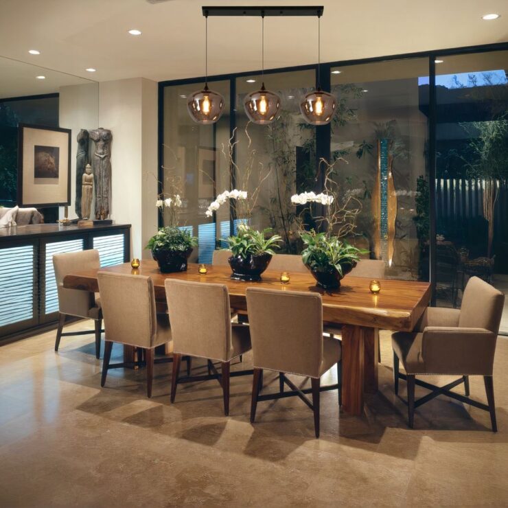 Lustre barre à suspensions boules ou tubes en verre allumé et suspendu au-dessus d'une table de salle à manger.