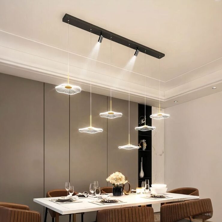 Lustre barre spots et fleurs suspendues en version noire, installé au-dessus d'une table de salle à manger dressée pour le dîner.