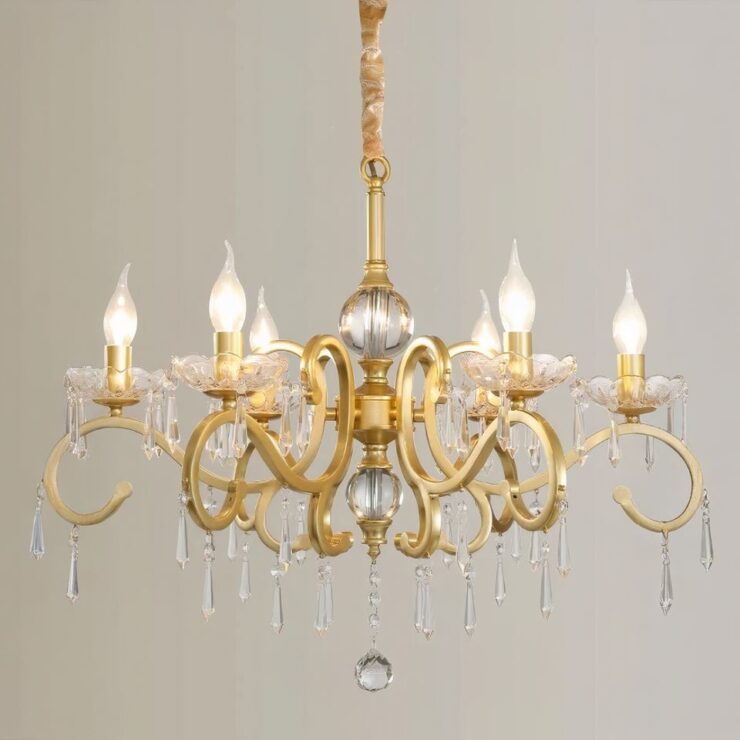 Lustre hollandais doré avec pampilles sur fond gris. Il est composé de plusieurs branches en métal doré sur lesquelles se trouvent des ampoules en forme de flamme de bougie allumées.