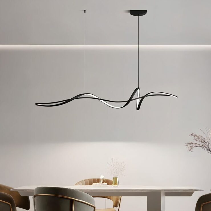 Un lustre minimaliste au design moderne suspendu de couleur noire fixé au plafond au-dessus d'une table rectangulaire beige. Il est suspendu à 2 câbles fins dont celui de droite est relié à un socle noir. Il diffuse une lumière naturelle. Il est composé d'une barre horizontale noire, enroulée d'une ligne noire munie de LED. Des fauteuils se trouvent autour de la table. Les murs sont blancs.