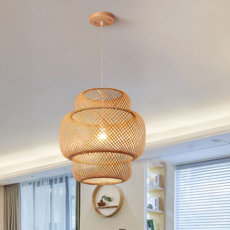 Lustre bohème bambou avec un design à deux niveaux, formé de bandes entrelacées créant une structure ajourée. Le luminaire émet une lumière douce et naturelle. Il est suspendu au plafond par un câble fin avec un socle en bois.