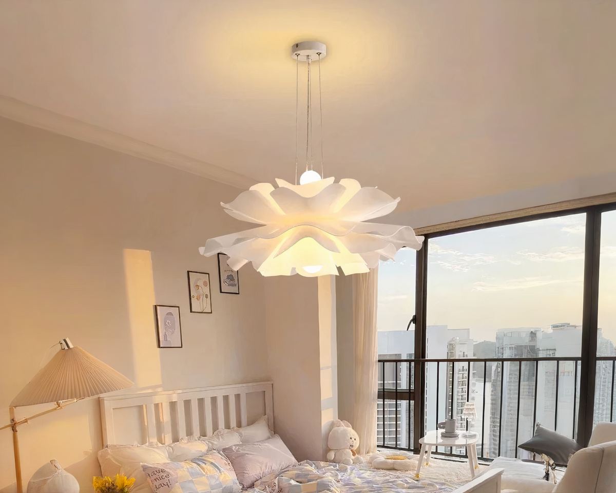 Un lustre chambre cocooning à effet floral suspendu au plafond. Il diffuse une lumière douce et chaleureuse, créant une atmosphère relaxante. Le design du lustre rappelle les pétales d'une fleur, parfait pour une ambiance apaisante dans une chambre lumineuse avec vue sur une grande fenêtre.