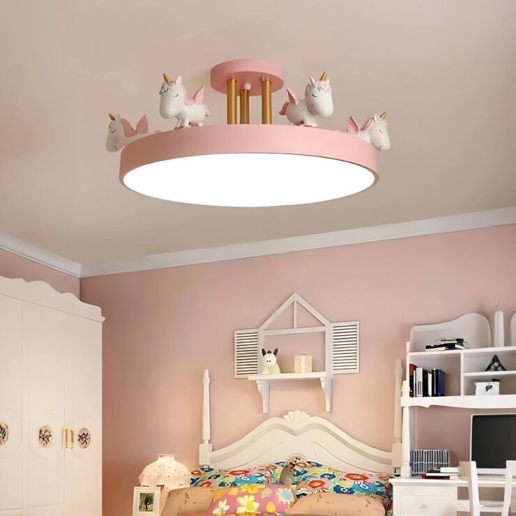 Un lustre chambre fille plafonnier avec licornes de forme ronde et de couleur rose est installé dans une chambre d'enfant aux tons roses avec des meubles blancs et un lit coloré.