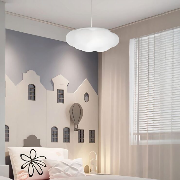 Un lustre enfant en forme de nuage est suspendu au plafond d'une chambre. La lumière est douce et diffuse.