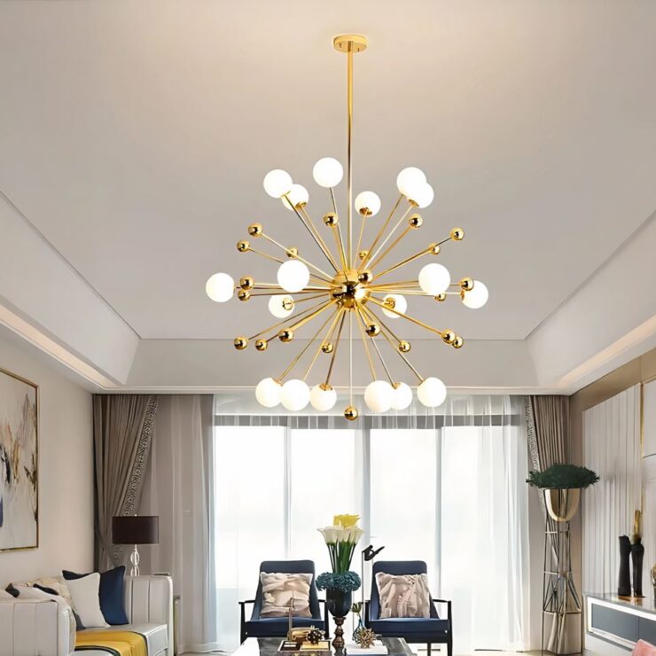 Un lustre spoutnik doré à globes lumineux est suspendu avec des bras métalliques, éclairant un salon moderne et élégant avec des fauteuils confortables et une grande baie vitrée en arrière-plan.