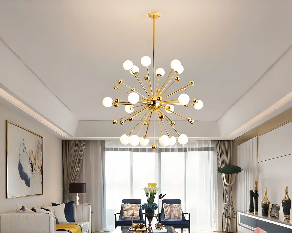 Un lustre spoutnik doré à globes lumineux est suspendu avec des bras métalliques, éclairant un salon moderne et élégant avec des fauteuils confortables et une grande baie vitrée en arrière-plan.