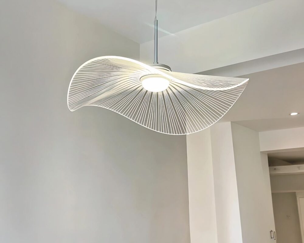 Un lustre vertigo blanc en acrylique est suspendu d'un plafond. Il crée un effet visuel léger et aérien.
