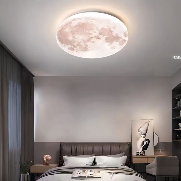 Lustre plafonnier lune chambre d'ado allumé et fixé au plafond d'une chambre aux tons gris et épurés. Il y a un cadre posé sur une table de chevet sur la gauche du lit.