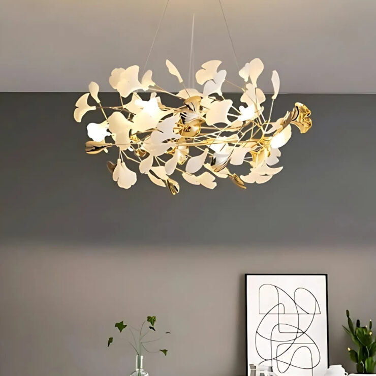 Lustre chic en forme de couronne de feuilles, suspendu dans une pièce et allumé. Le mur du fond est de couleur grise.