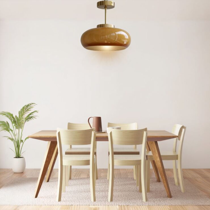 Lustre années 50 rond en verre ambré ou verre blanc suspendu au dessus d'une table de salle à manger au style très épuré et sur fond de mur blanc.