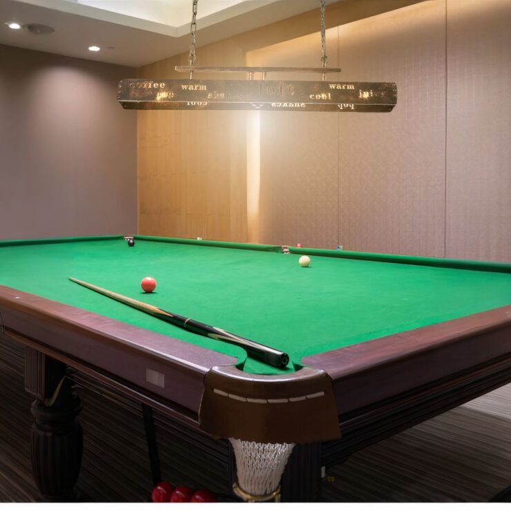 Lustre billard design moderne industriel suspendu au-dessus d'un grand billard.