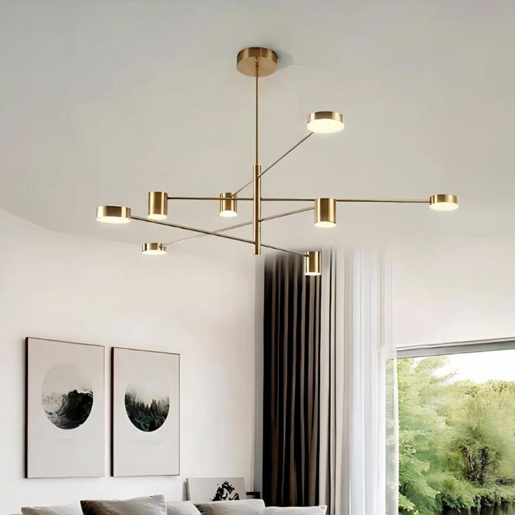 Lustre bureau design multispots en version dorée et suspendu dans une pièce avec une fenêtre et deux tableaux accrochés au mur.