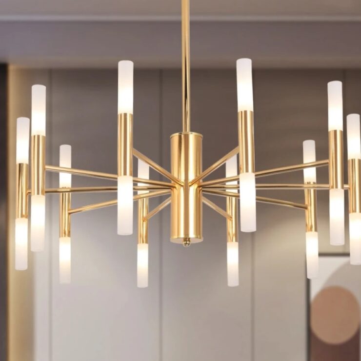 Lustre XXL, suspendu, les leds sont allumées. Il est suspendu au plafond. Le fond de l’image est flouttée et on apperçoit un cadre photo avec des formes géométriques.