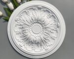Cache plafond rond en plâtre pour lustre, orné de motifs floraux en relief, ajoutant une touche élégante et raffinée au plafond, parfait pour sublimer l'installation d'un lustre.