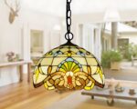 Lustre art déco 1930 style méditerranéen avec abat-jour en vitrail coloré, suspendu par une chaîne. Il diffuse une lumière douce et chaleureuse, apportant une touche artistique et méditerranéenne à la pièce.