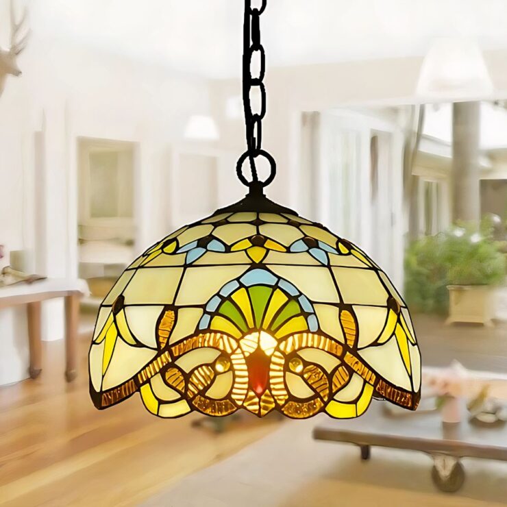 Lustre art déco 1930 style méditerranéen avec abat-jour en vitrail coloré, suspendu par une chaîne. Il diffuse une lumière douce et chaleureuse, apportant une touche artistique et méditerranéenne à la pièce.