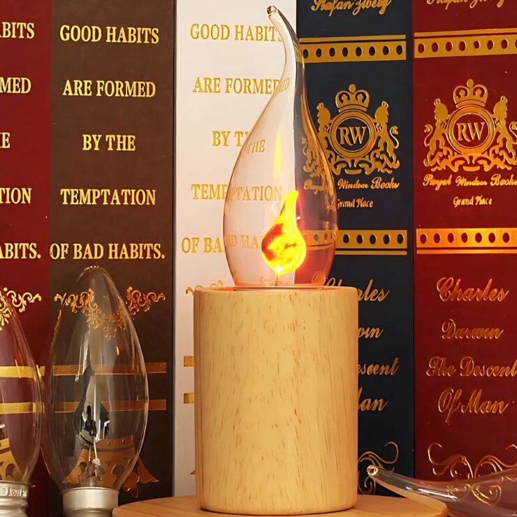 Ampoule lustre LED en forme de bougie à la flamme vacillante dans un bougeoir en bois et posé sur un meuble qui semble être une bibliothèque.