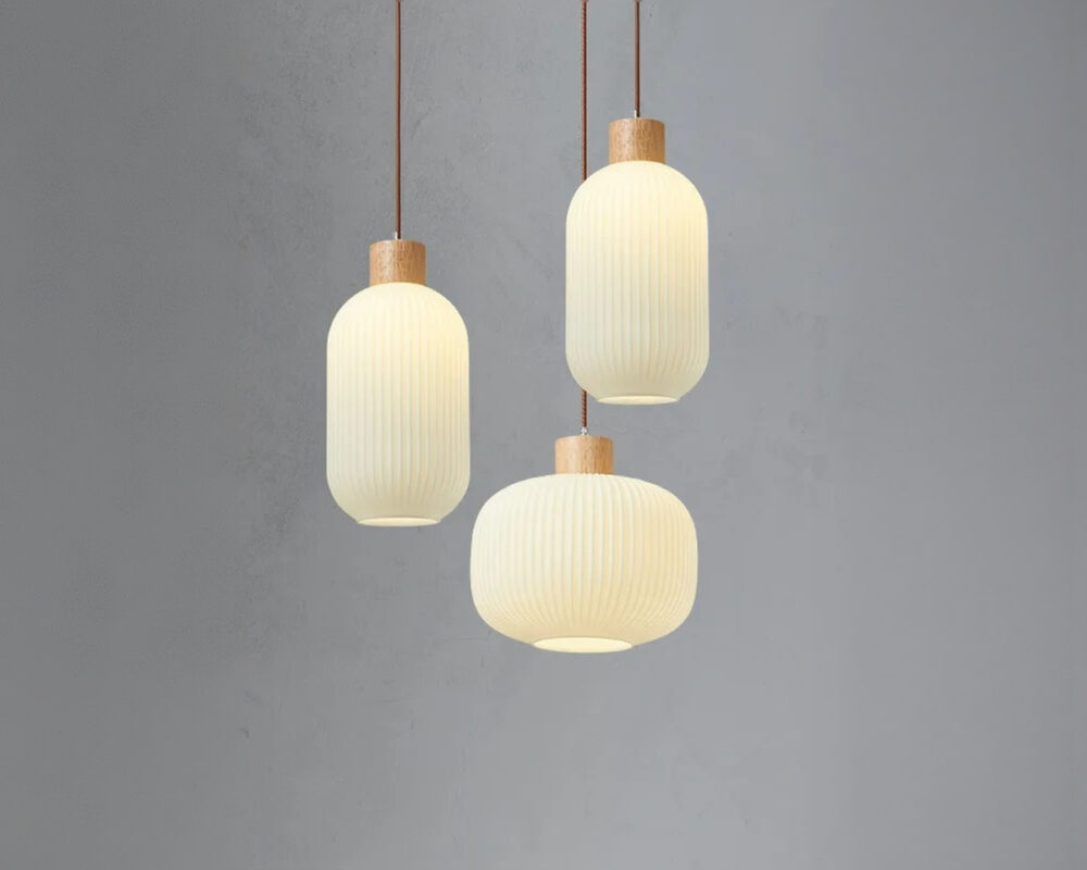 Trio de lustre japandi suspendu bois et verre sur fond uni