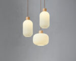 Trio de lustre japandi suspendu bois et verre sur fond uni
