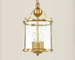 Lustre classique finition bronze poli en forme de lanterne cylindrique sur fond uni