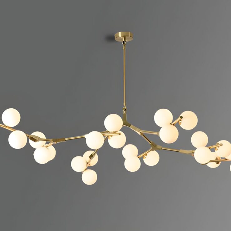 Lustre doré avec des branches et des boules en verre blanches au bout, sur fond gris