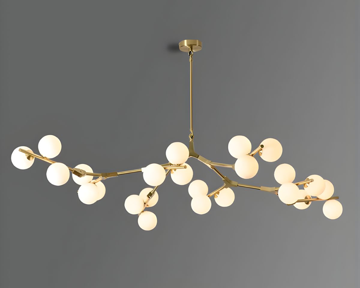 Lustre doré avec des branches et des boules en verre blanches au bout, sur fond gris