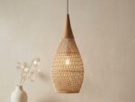 Lustre naturel en rotin tressé en forme de goutte, au dessus d'une table