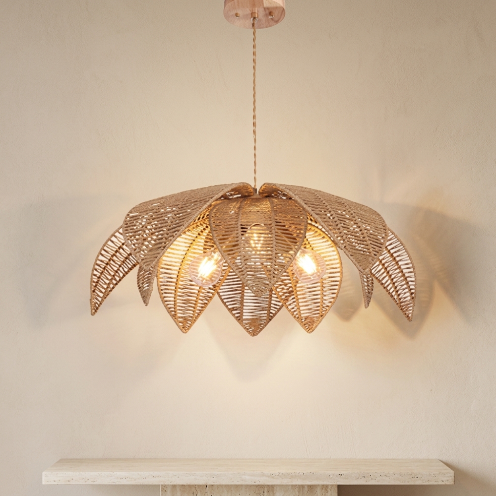Lustre Bali en forme de fleur en rotin tressé, devant un mur beige