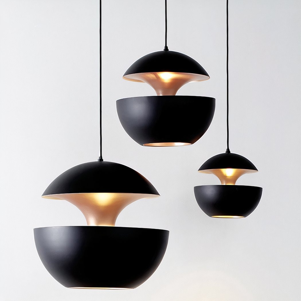Trois suspensions en forme de boule, le lustre boule design noir intérieur doré, avec extérieur noir et lumière chaude dorée, suspendues sur un fond blanc minimaliste.